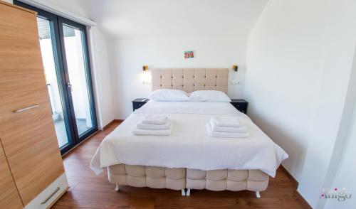 a bedroom with a large white bed with towels on it at Bunska Venera in Blagaj