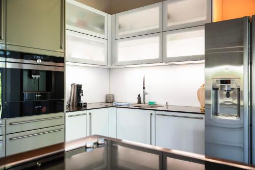 a kitchen with white cabinets and a refrigerator at Villa von Maximus in Leipzig