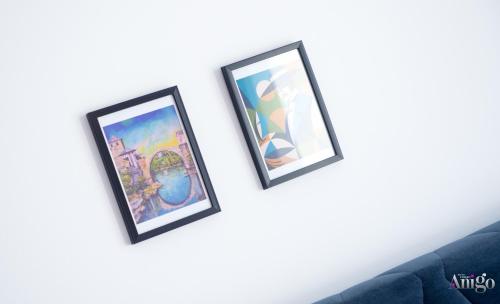three framed pictures on a wall next to a couch at Bunska Venera in Blagaj