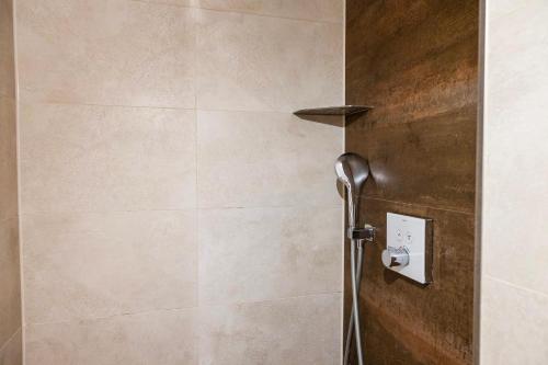 a shower in a bathroom with a tile wall at Villa von Maximus in Leipzig