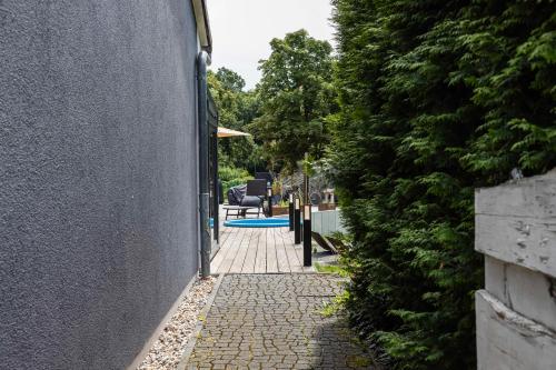 a walkway next to a house with a hedge at Villa von Maximus in Leipzig