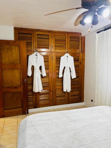 a bedroom with a bed and two shirts on hangers at Exclusive Altos del Maria 2 Bedroom Apartment-Private Pool & Mountain Views in Sorá