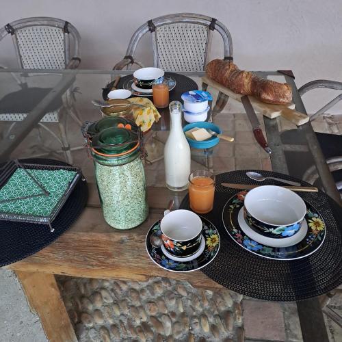 een tafel met borden en borden erop bij Chambres d hotes proche Macon in Grièges