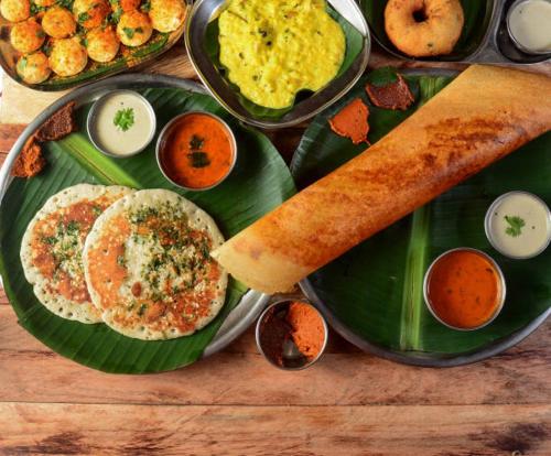 a green plate of food with eggs and bread on it at Veeru Homestay in Hospet