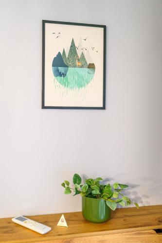 a plant on a table with a picture on the wall at Mursala Pamporovo in Pamporovo