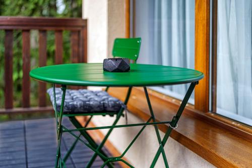 a green table and a chair on a porch at Mursala Pamporovo in Pamporovo