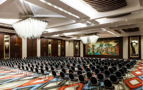 a large room with chairs and a chandelier at Mövenpick Ambassador Hotel Accra in Accra