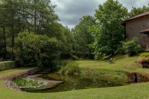 a pond in a garden next to a building at El Molino de Bonaco in San Vicente de la Barquera