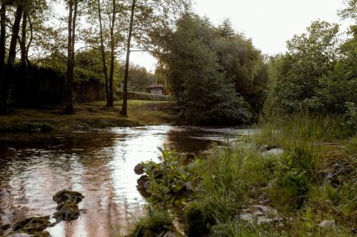 a river with a house in the middle of it at El Molino de Bonaco in San Vicente de la Barquera