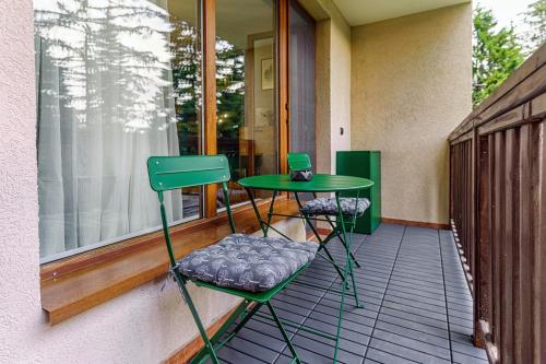 a green table and two chairs on a porch at Mursala Pamporovo in Pamporovo