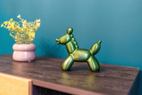 a green dinosaur figurine on a table with a vase of flowers at Mursala Pamporovo in Pamporovo