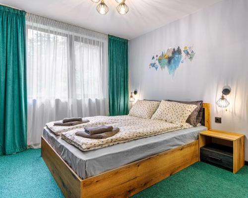 a bedroom with a bed and a window with green curtains at Mursala Pamporovo in Pamporovo