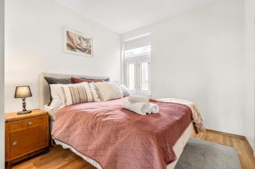 a bedroom with a bed with a night stand and a window at Central Big and Bright Resting place in Trondheim