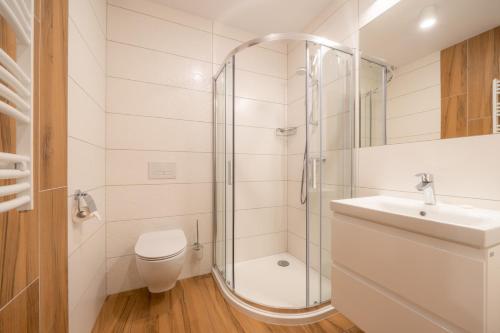 a bathroom with a shower and a toilet and a sink at Willa Marti GOLD in Zakopane