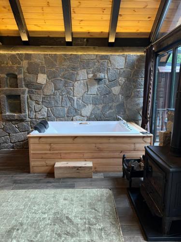 a bath tub sitting next to a stone wall at AYDER VANAK STONE SUİTES in Ayder Yaylasi