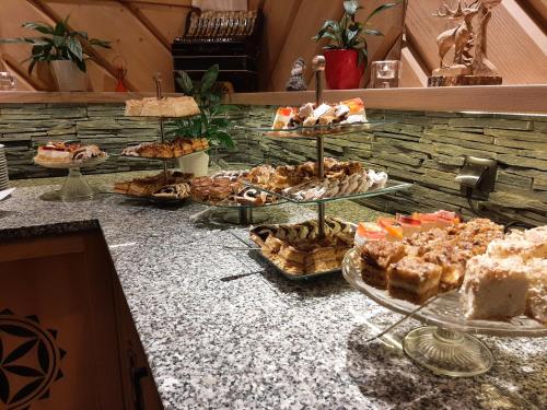 a table with several plates of pastries on a counter at Willa Marti GOLD in Zakopane