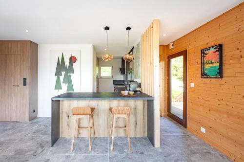 a kitchen with a counter and two stools at Chalet Les Genêts, vue imprenable sur le lac in Gérardmer