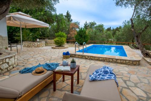 a patio with a pool and a table and chairs at Kalokairia Residence in Gaios