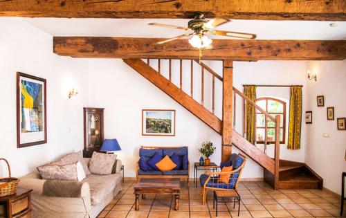 a living room with a couch and a ceiling fan at Domaine Saint Ferreol in Nizas