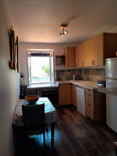 une cuisine avec des armoires en bois, une table et une fenêtre dans l'établissement Holiday à Hyères plage repos balade sport mer bleu, à Hyères