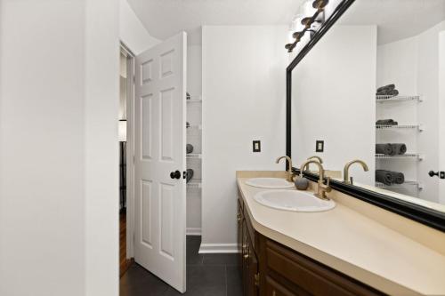 a bathroom with two sinks and a large mirror at 5 Minutes from Hospitals and UK! in Lexington