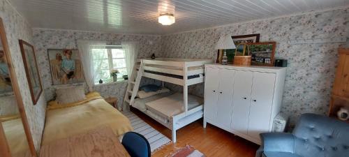 a bedroom with a bed and a bunk bed at Fridfullt sommarhus mitt på Österlen nära Simrishamn, Tomelilla och Ystad in Gärsnäs