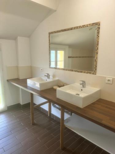 une salle de bain avec deux lavabos et un grand miroir dans l'établissement La Maison Colette, à Les Eyzies-de-Tayac