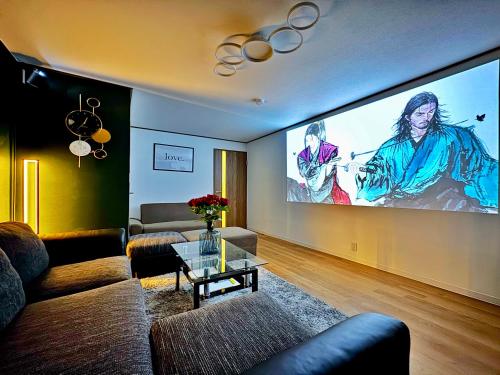 a living room with a large projection screen at guesthouse大阪城 in Osaka