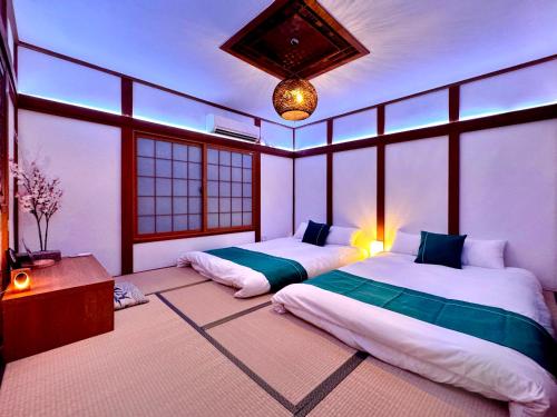 a bedroom with two beds in a room with windows at guesthouse大阪城 in Osaka