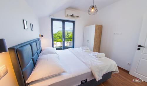 a large bed in a room with a large window at Bunska Venera in Blagaj