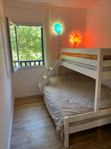 une chambre avec un lit superposé et une fenêtre dans l'établissement Maison avec piscine sur le golf - plage à 600m, à Moliets-et-Maa
