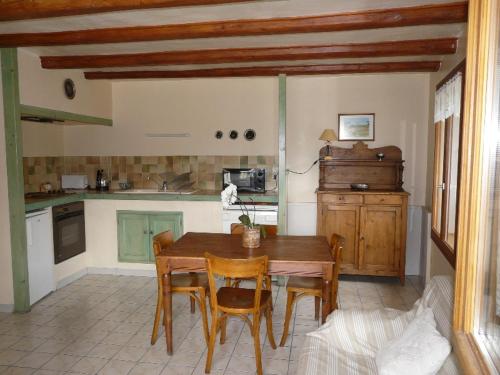 Il comprend une cuisine avec une table et des chaises en bois. dans l'établissement La PASTOURELLE, à Villard-de-Lans