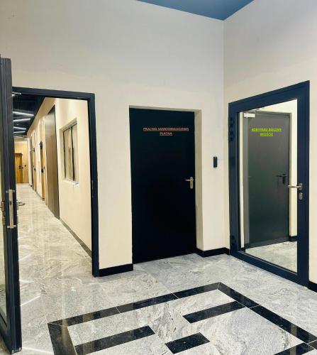 a hallway with two black doors in a building at LOFTY NAD WARTĄ Apartament FREE PARKING in Poznań