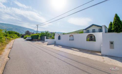 an empty street with a white building and a house at Bunska Venera in Blagaj