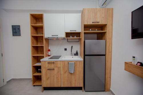 a kitchen with a sink and a refrigerator at LA PLAZA luxury suites NEA VRASNA in Nea Vrasna