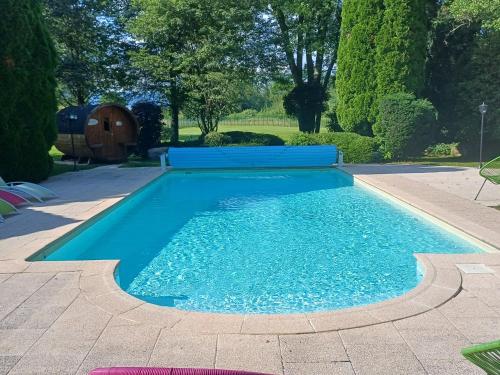 une piscine avec de l'eau bleue dans une cour dans l'établissement Domaine de Chalétang, à Belfort