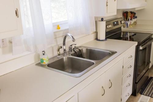 a kitchen counter with a sink and a stove at Vintage OBX in Sanderling