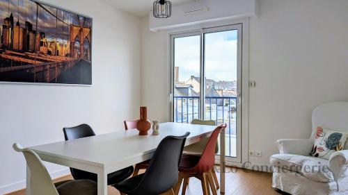 une salle à manger avec une table et des chaises blanches dans l'établissement Elégant Appartement au Coeur de Redon, à Redon