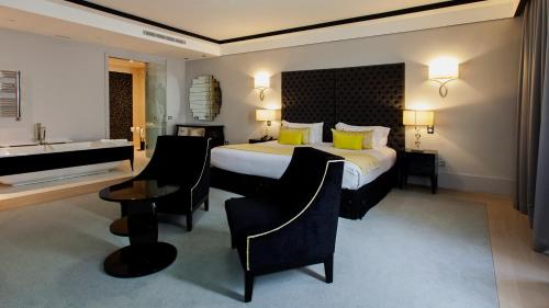 a hotel room with a large bed and a bathroom at Alentejo Marmòris Hotel & Spa in Vila Viçosa
