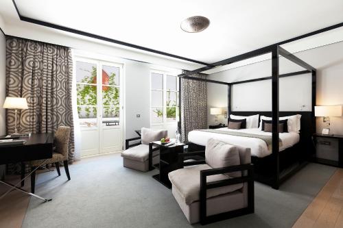 a hotel room with a bed and a desk and a chair at Alentejo Marmòris Hotel & Spa in Vila Viçosa