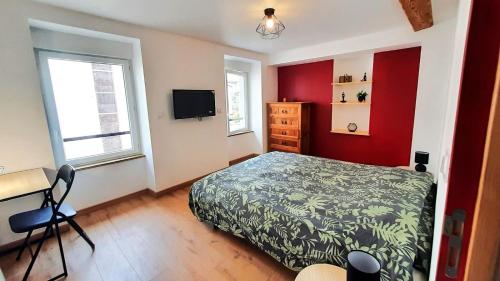 a bedroom with a bed and a desk and a tv at Au mignon filet de St Nazaire in Saint-Nazaire-en-Royans