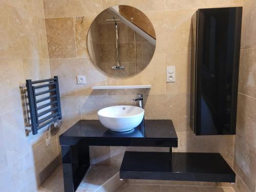 a bathroom with a bowl sink and a mirror at Le domaine du chêne vert in Monthou-sur-Bièvre