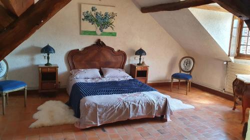 a bedroom with a large bed and two chairs at Le domaine du chêne vert in Monthou-sur-Bièvre