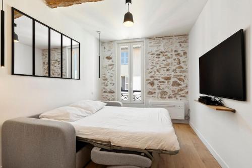 une chambre avec un lit et une télévision à écran plat dans l'établissement B066 Studio design à 5 mn de la plage, à Cannes