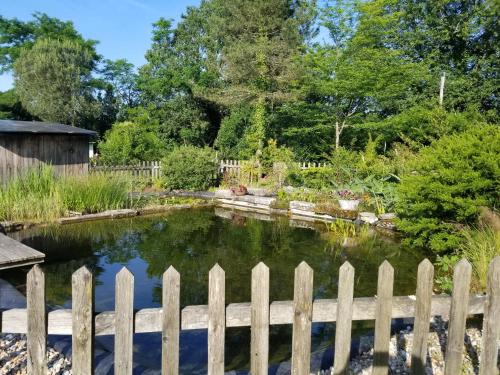 un étang dans un jardin derrière une clôture dans l'établissement séjour en yourte, à Gans