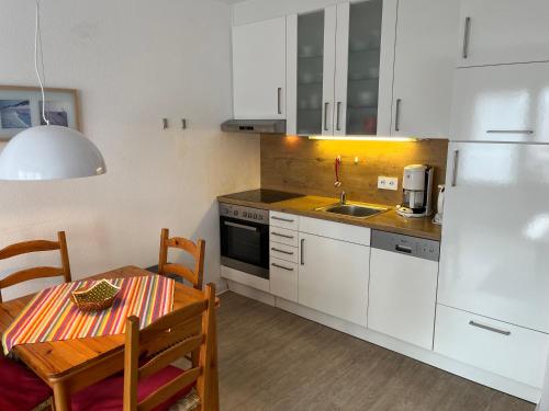 una cucina con un tavolo e un frigorifero bianco di Sonnige Ferienwohnung a Borkum