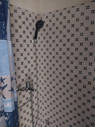 a shower with a black and white tiled wall at dimora del pescatore in Savelletri di Fasano