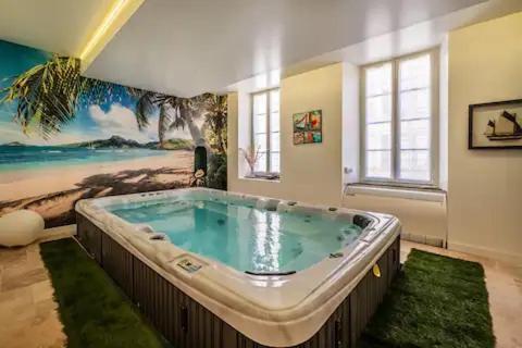 une grande baignoire dans une chambre avec une plage dans l'établissement Le clos des jacobins, à Narbonne