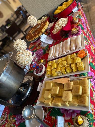 Gran lençóis Flat 2 suítes vista piscina في باريرينهاس: طاولة بها ثلاث صواني من الجبن والأطعمة الأخرى