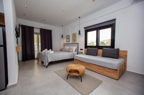 a living room with two beds and a chair at LA PLAZA luxury suites NEA VRASNA in Nea Vrasna